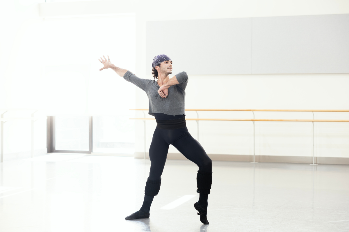 Ballet dancer in rehearsal studio performing a graceful pose