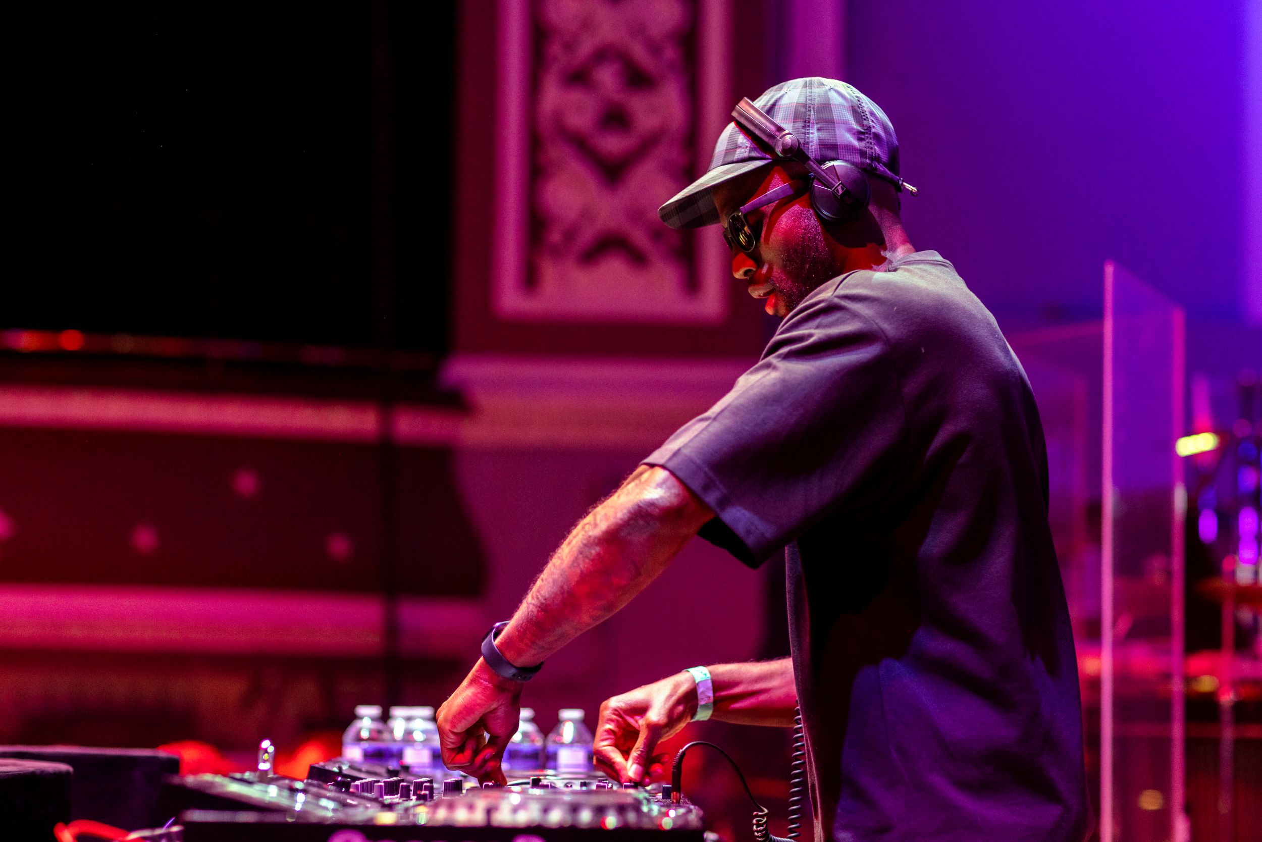 DJ performing on stage with vibrant purple lighting