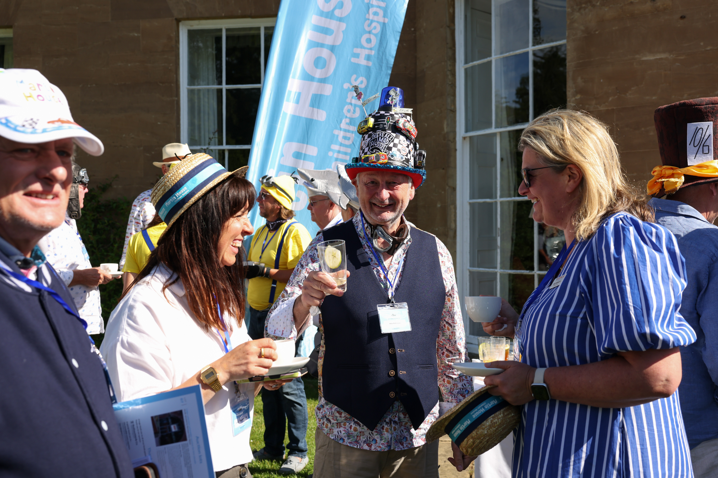 Group of people in festive hats enjoying a sunny outdoor event