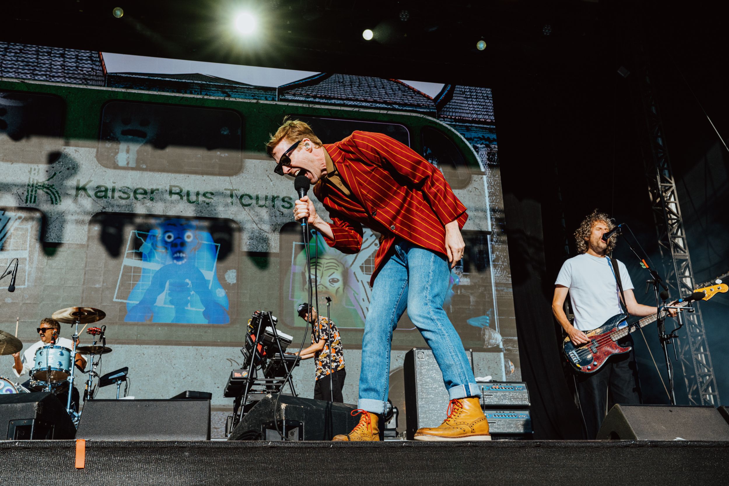 Energetic band performing on stage with vibrant backdrop