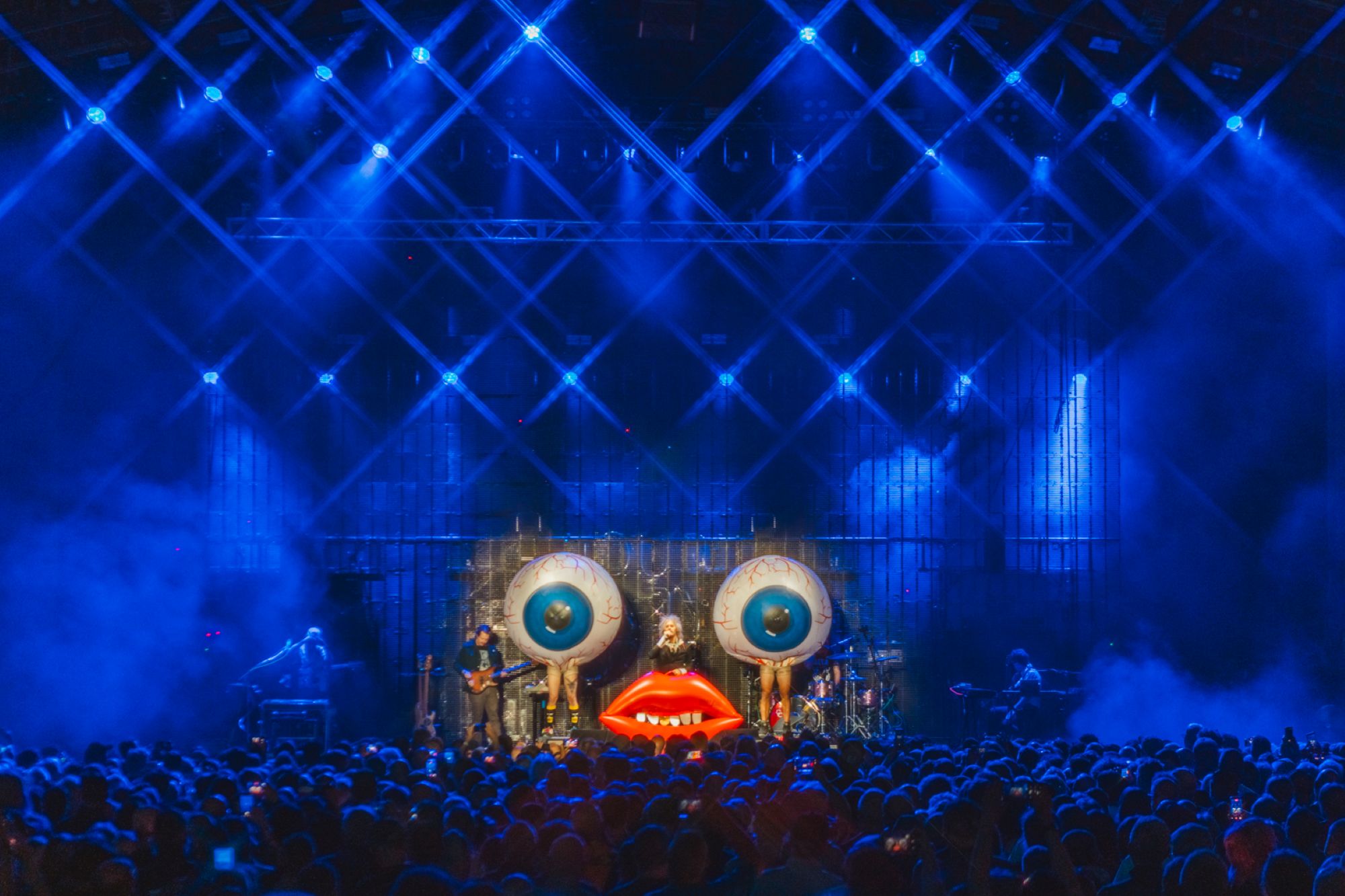 Concert stage with giant eye decorations and blue lighting