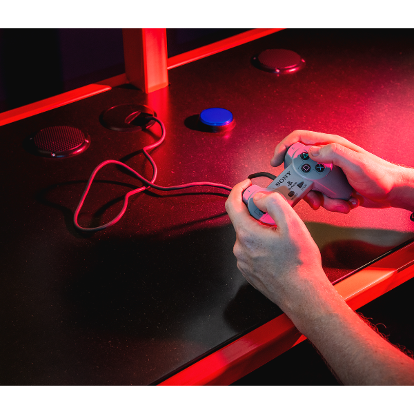 Hands playing retro video game on console with red lighting