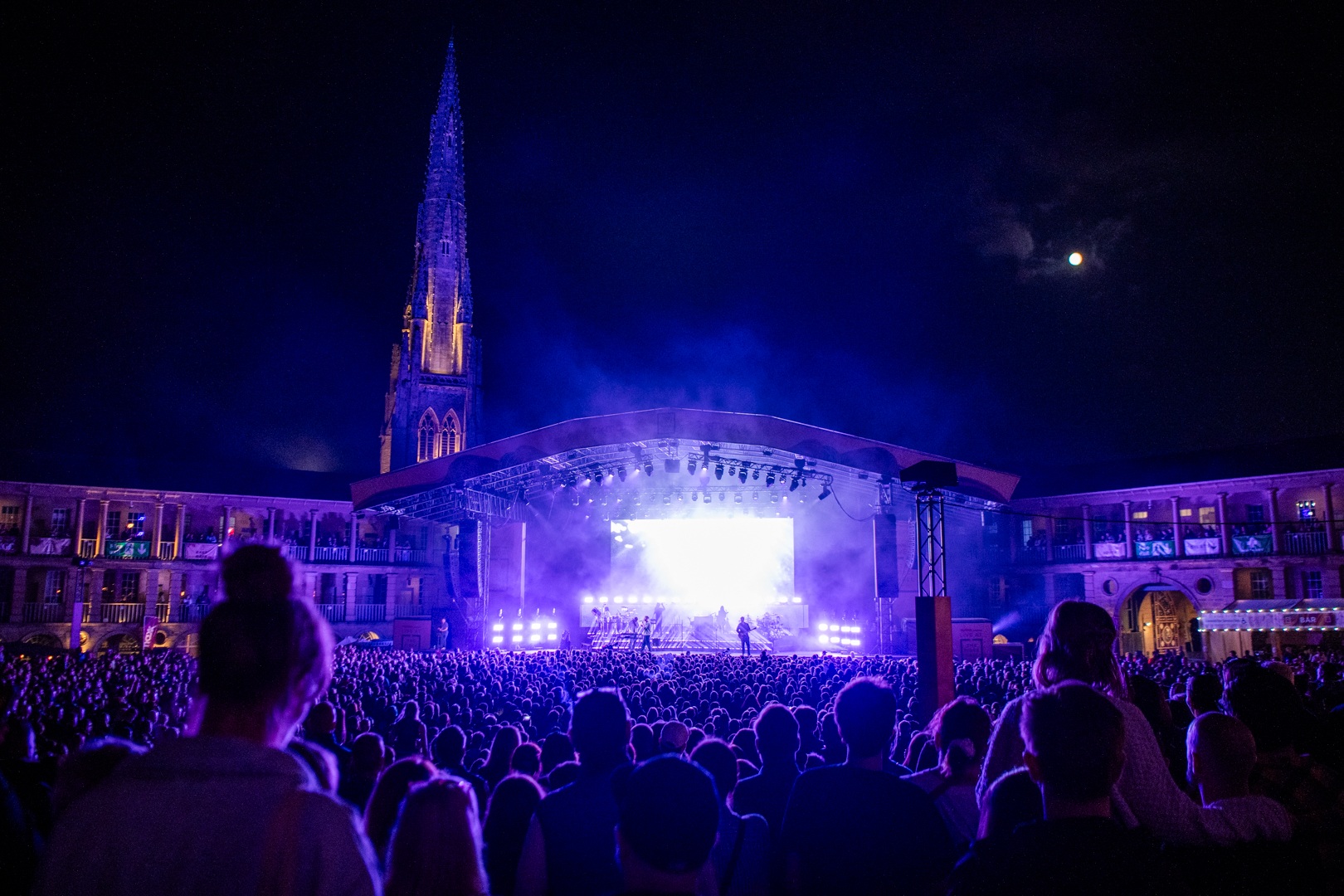Night concert at Halifax Piece Hall with illuminated spire