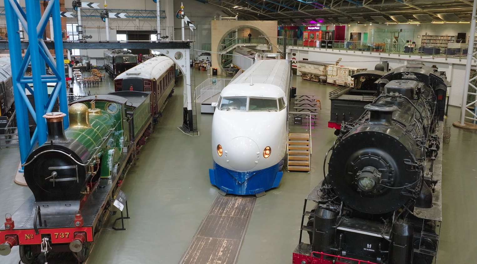 Historic steam and modern trains in railway museum hall