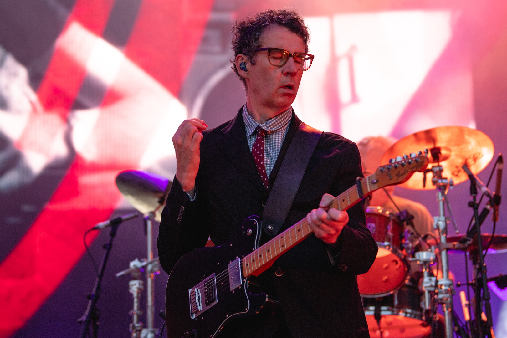 Musician playing electric guitar on colorful stage