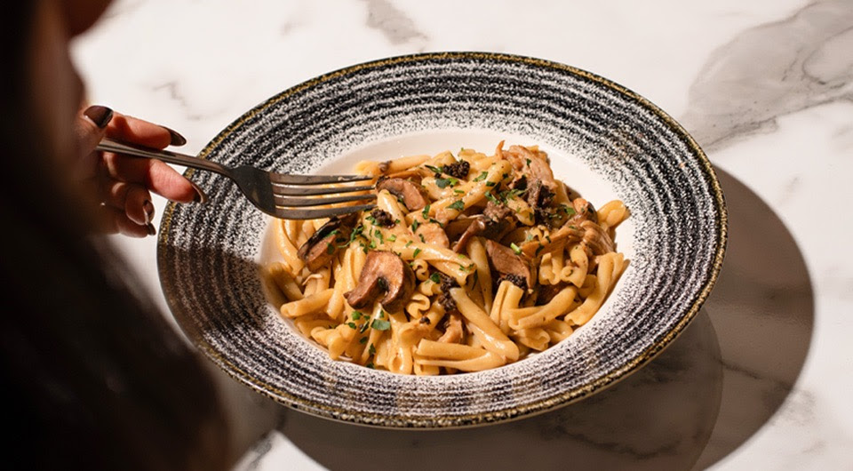 Close-up of a creamy mushroom pasta dish on a marble table