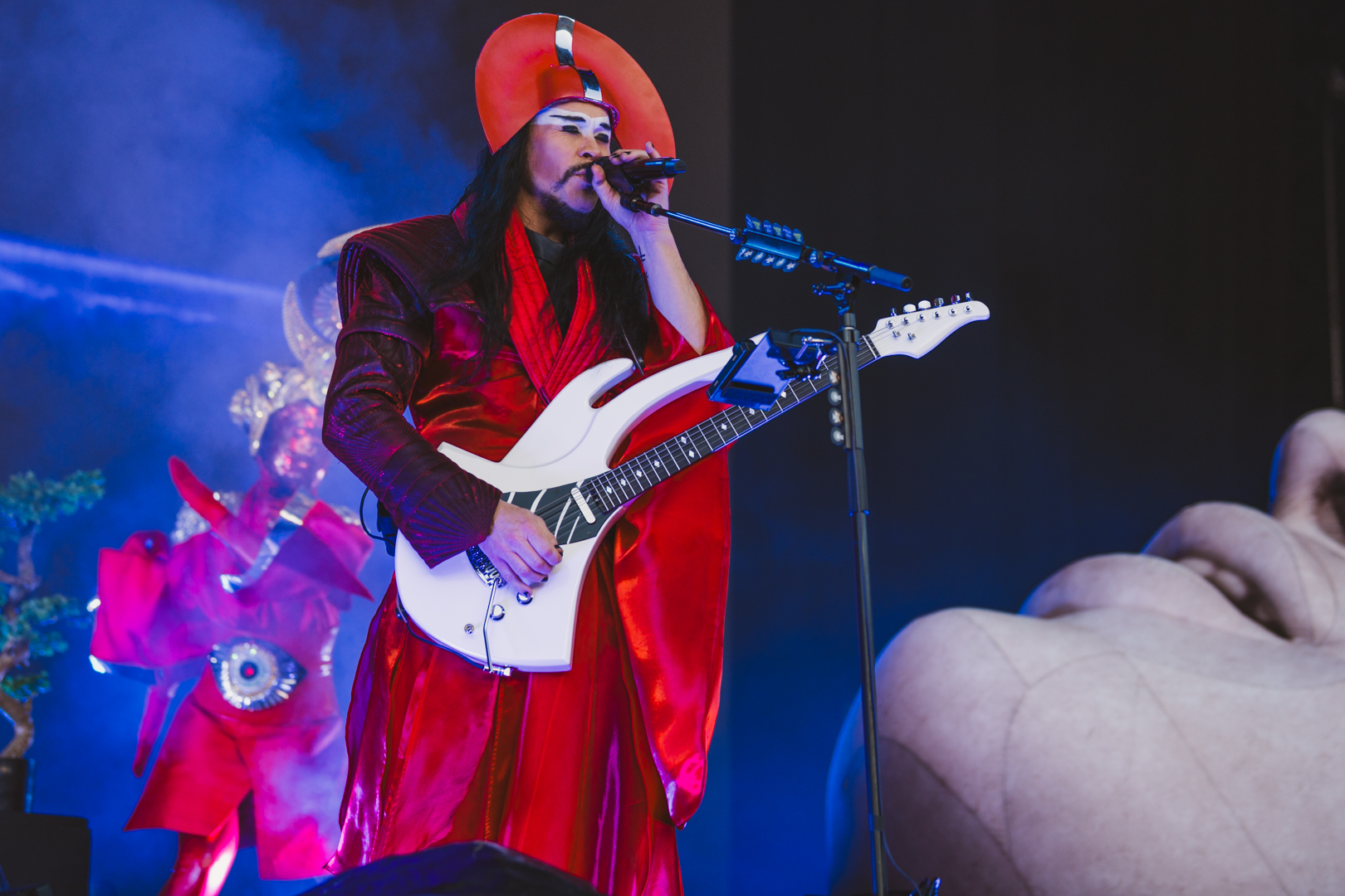 Performer in vibrant red costume playing electric guitar
