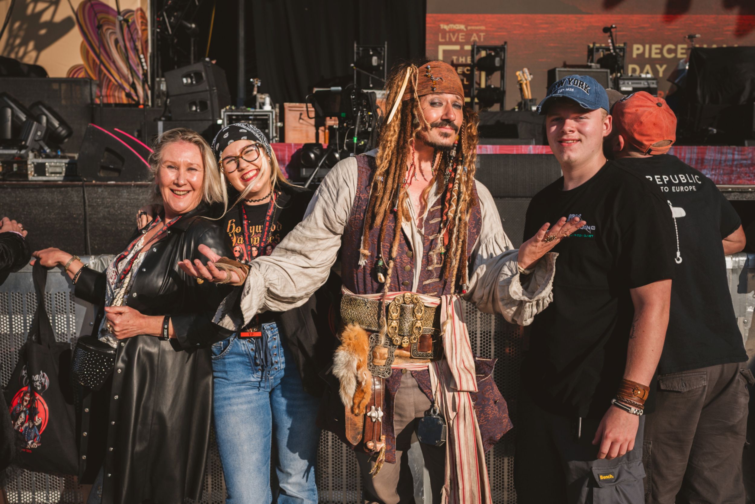 Group of people smiling with a pirate character at a festival