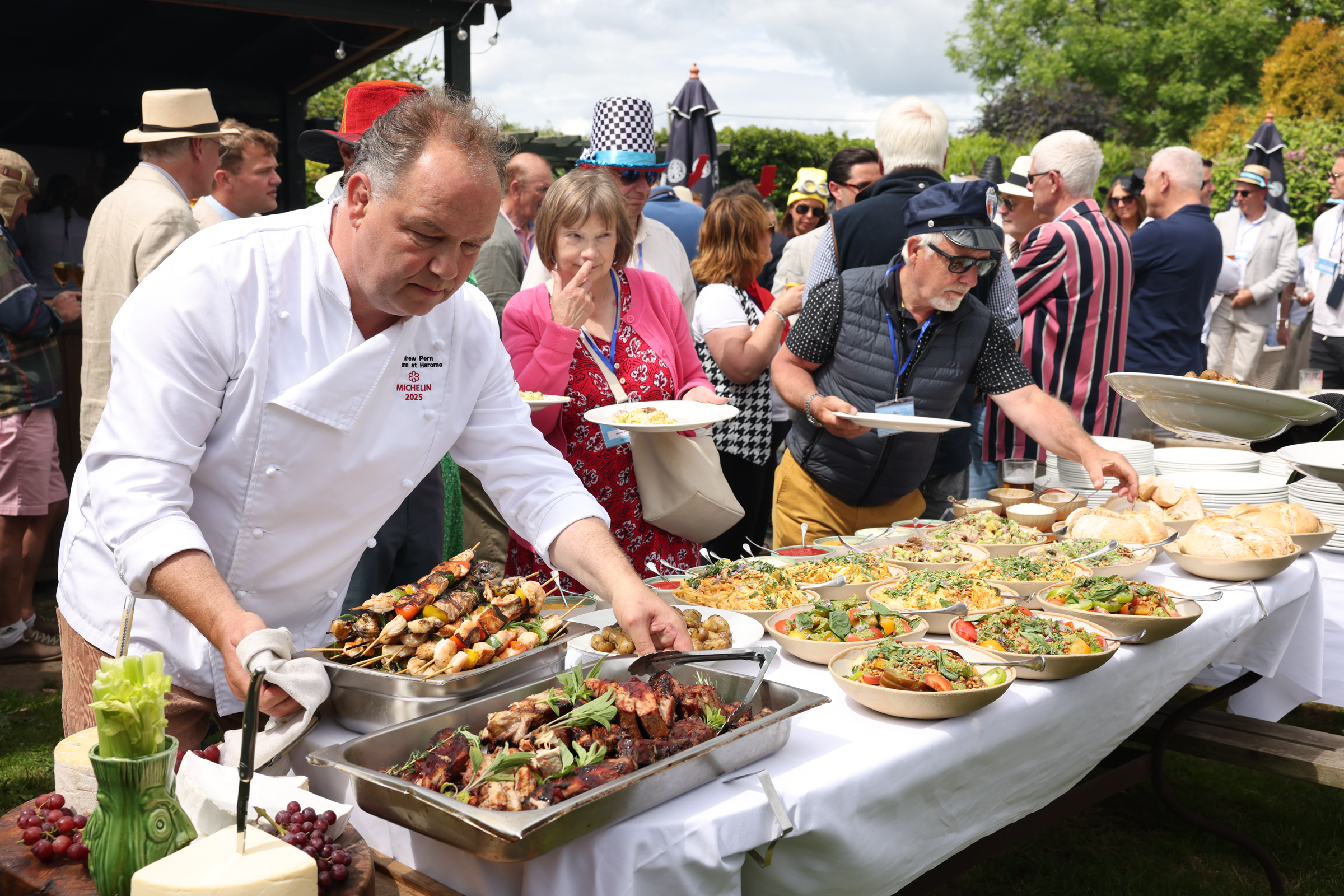 Chef serving grilled skewers at outdoor food festival