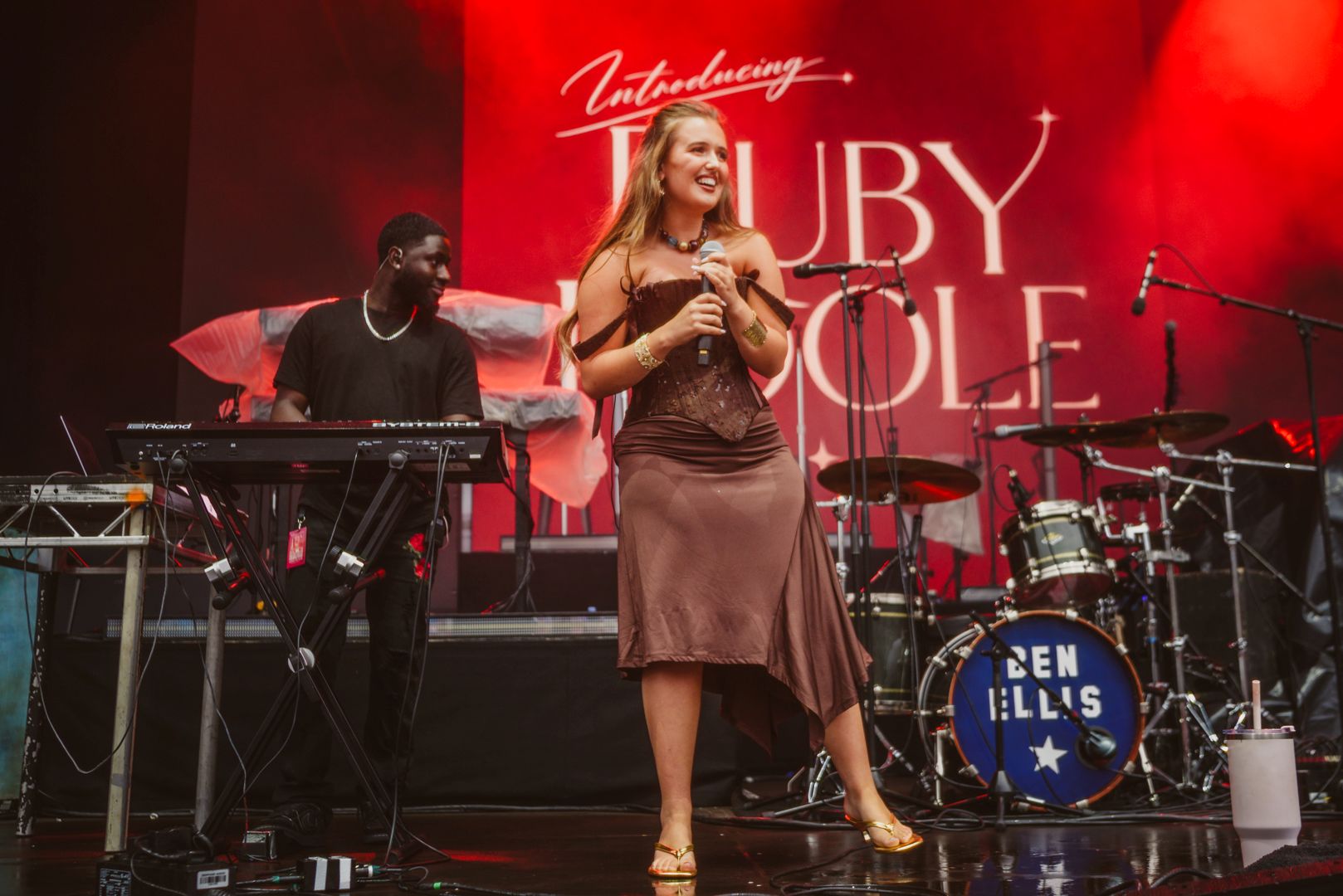 Singer performing on stage with keyboard and drums