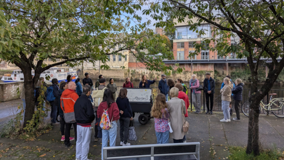 Group of tourists gathered by a riverside with guide