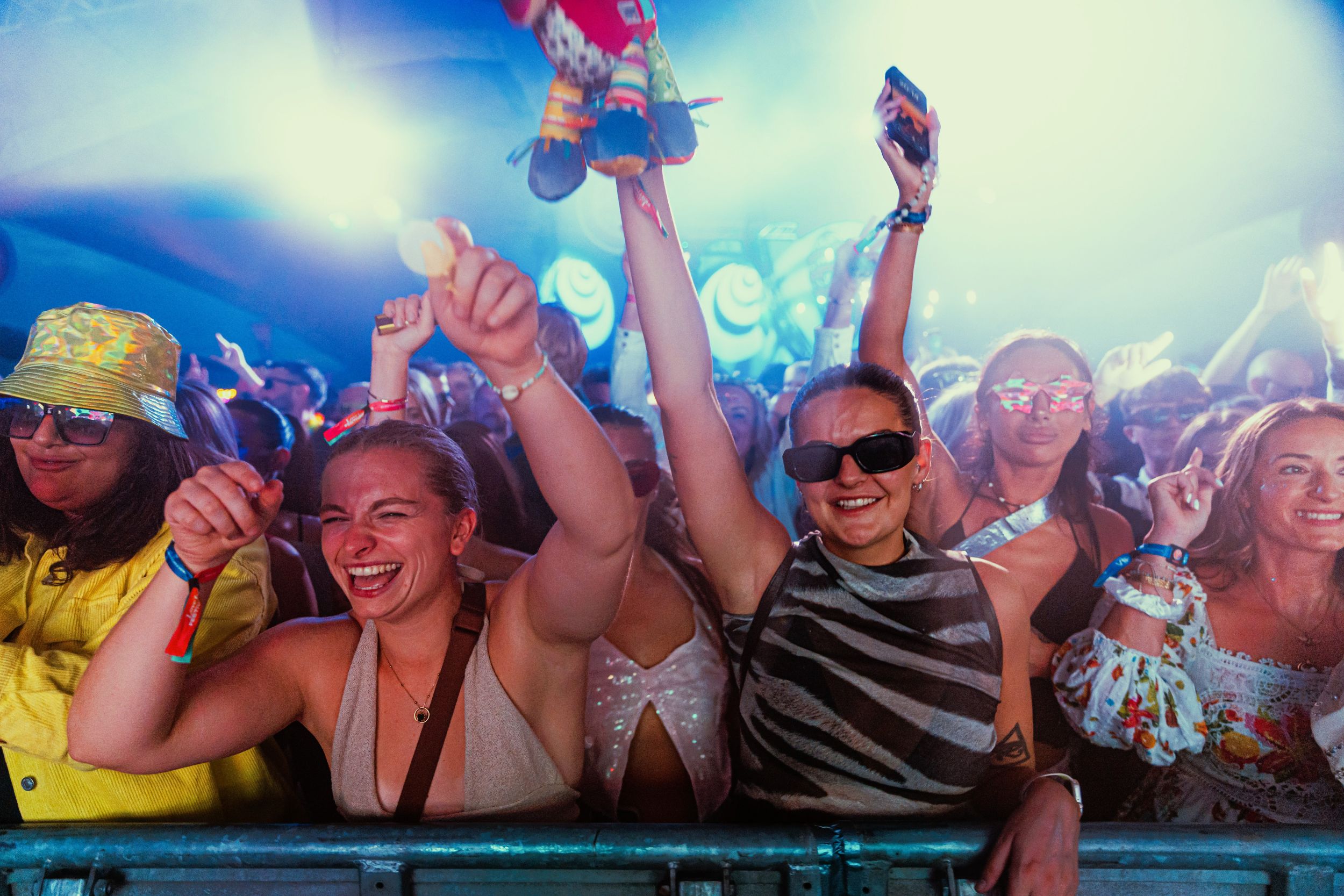 Festival crowd dancing under colorful lights at night