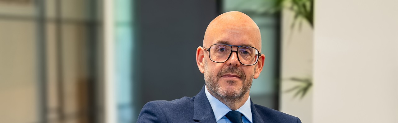 Businessman in glasses and suit seated in modern office