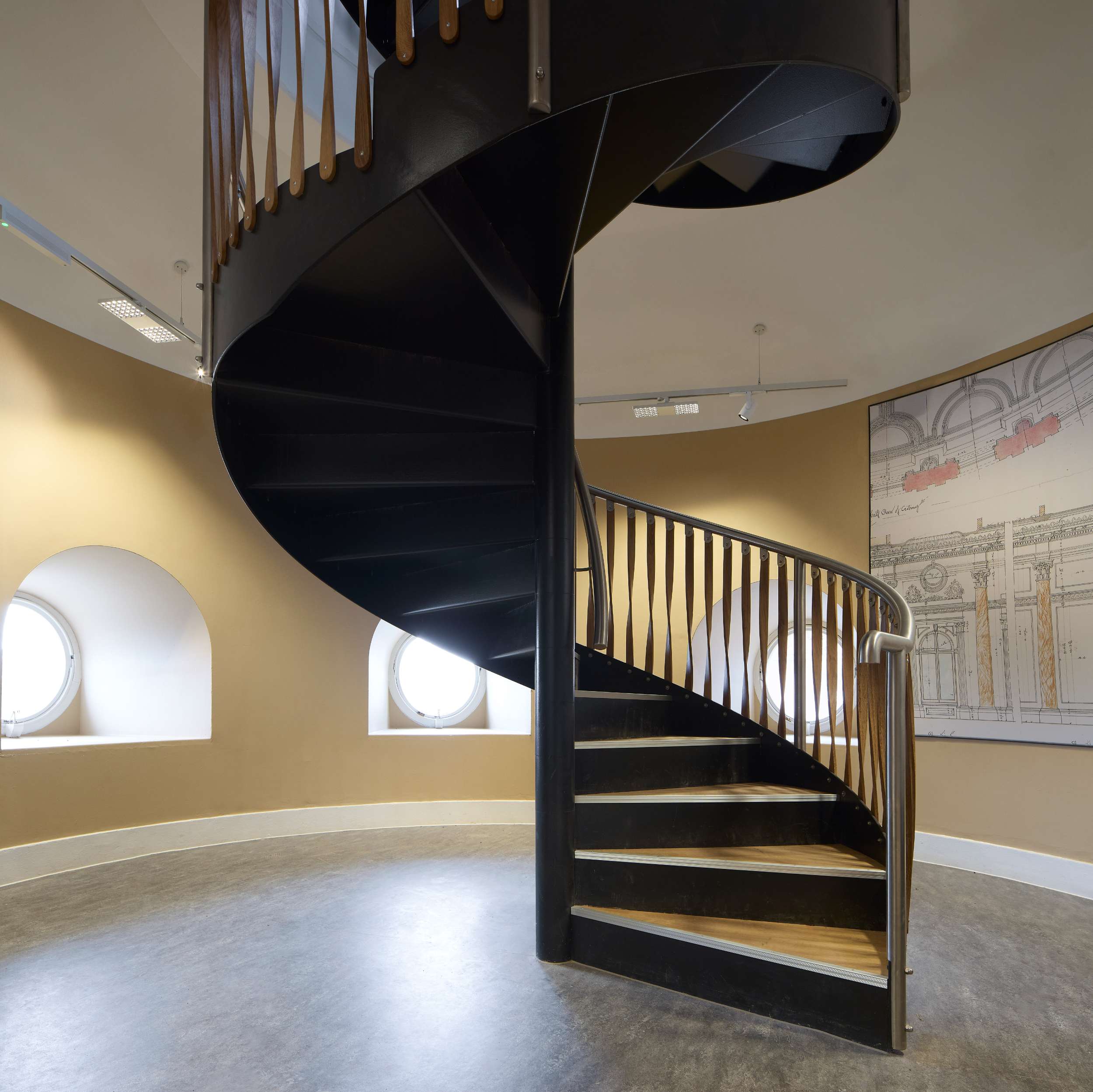Spiral black staircase in modern interior with round windows