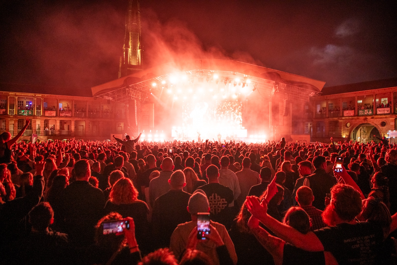 Crowd enjoying a live concert at night with vibrant lighting