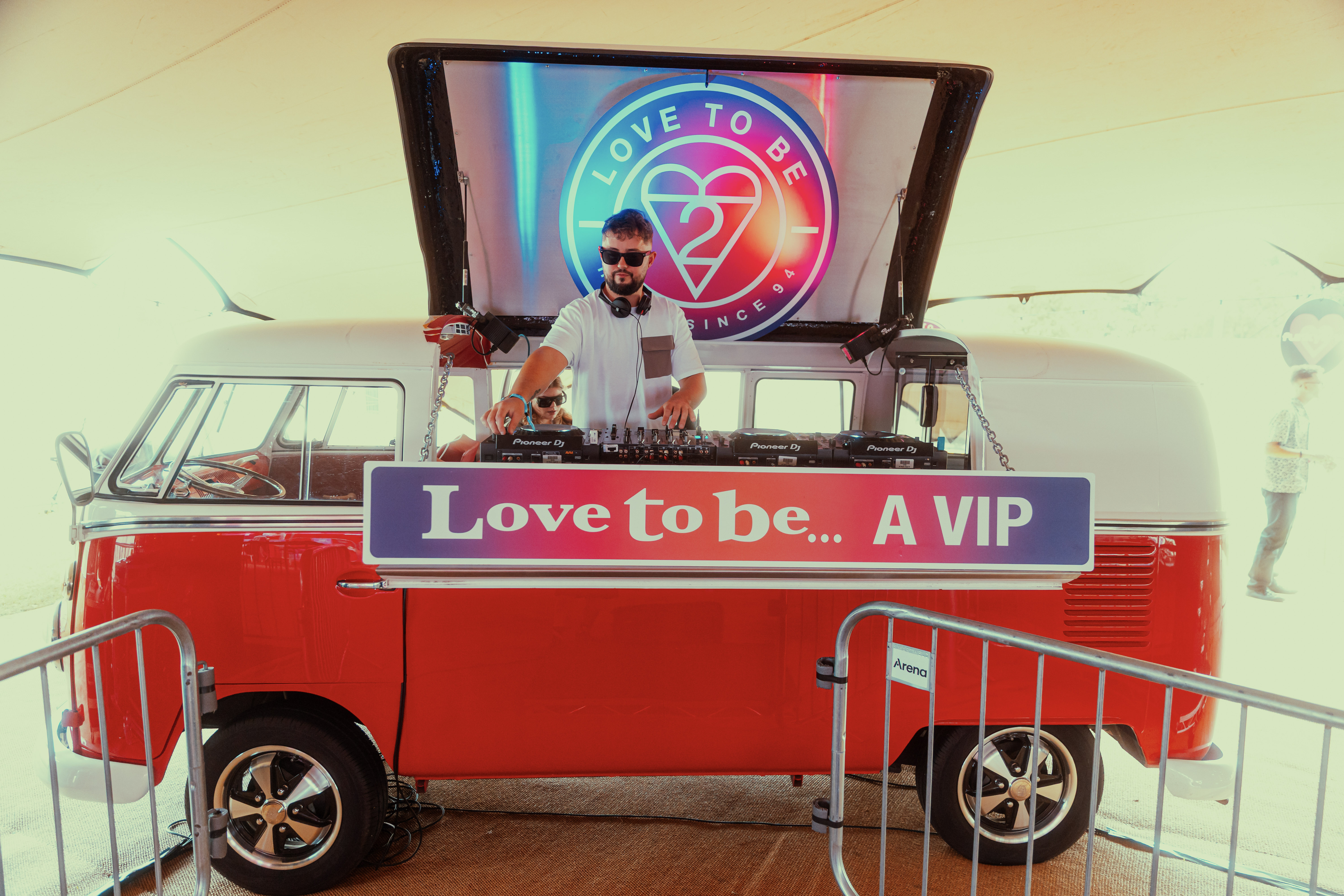 DJ performing in retro VW van with love-themed decor