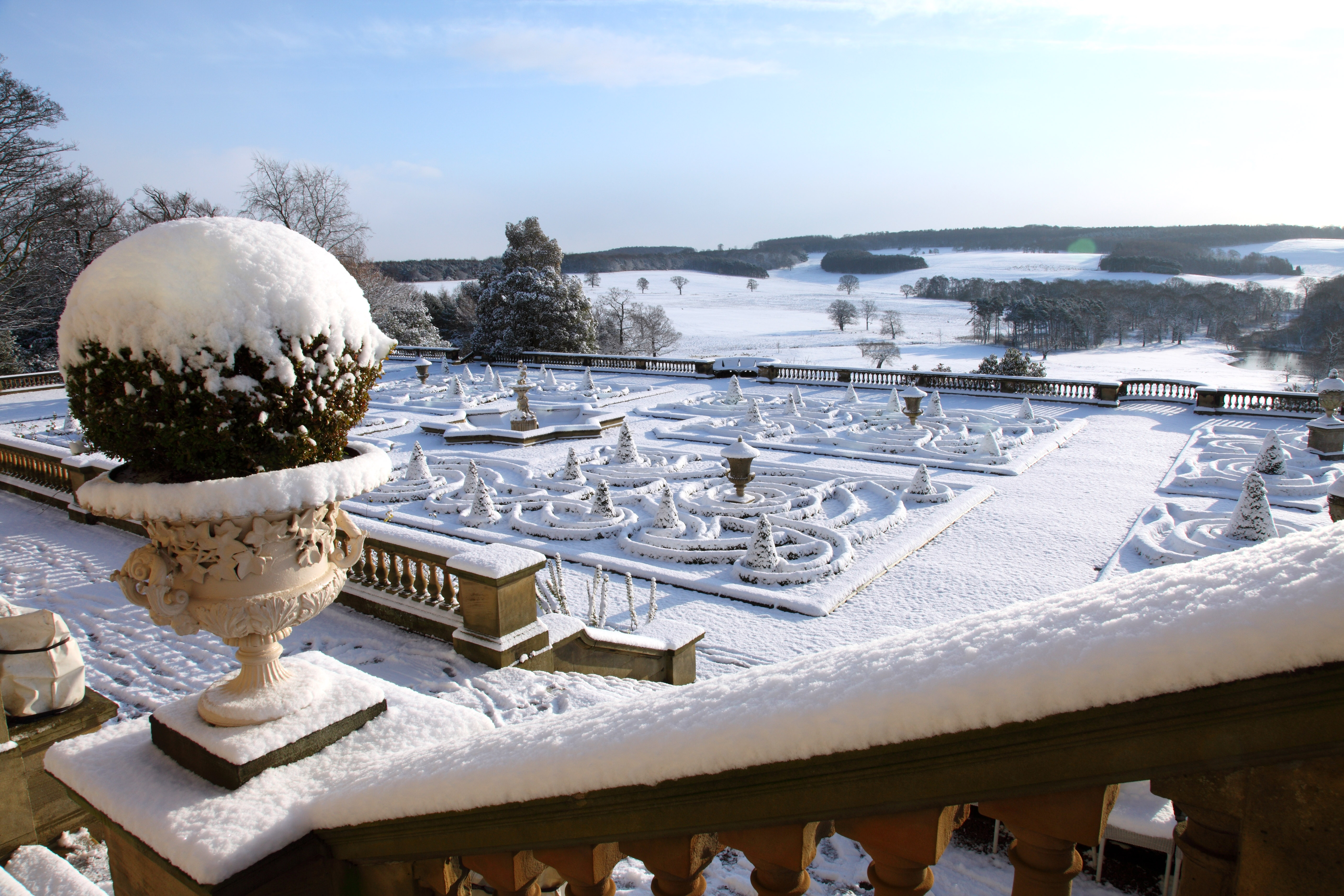 Snow-covered formal garden with ornate stone balustrade