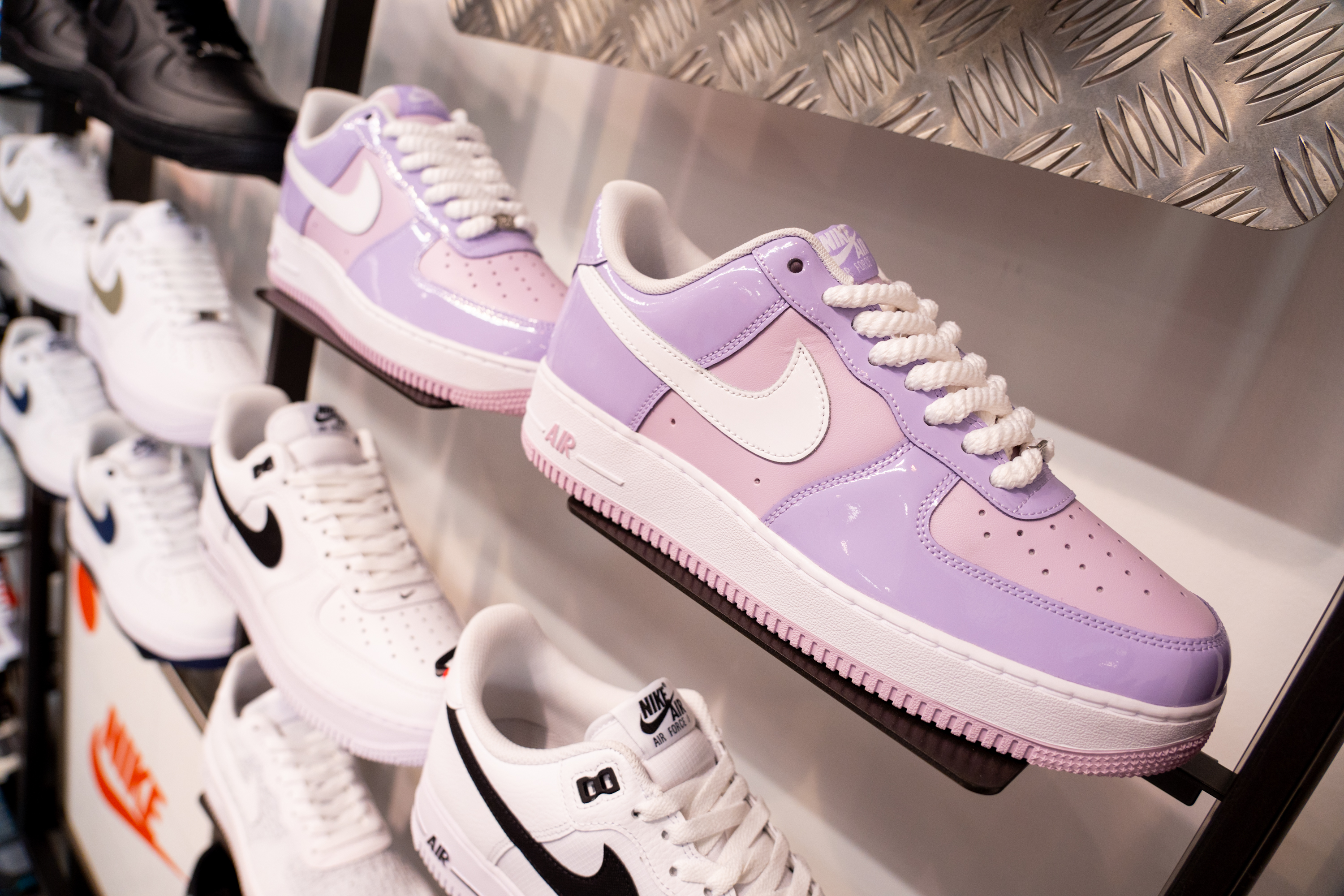 Display of pastel purple and white sneakers on shelf
