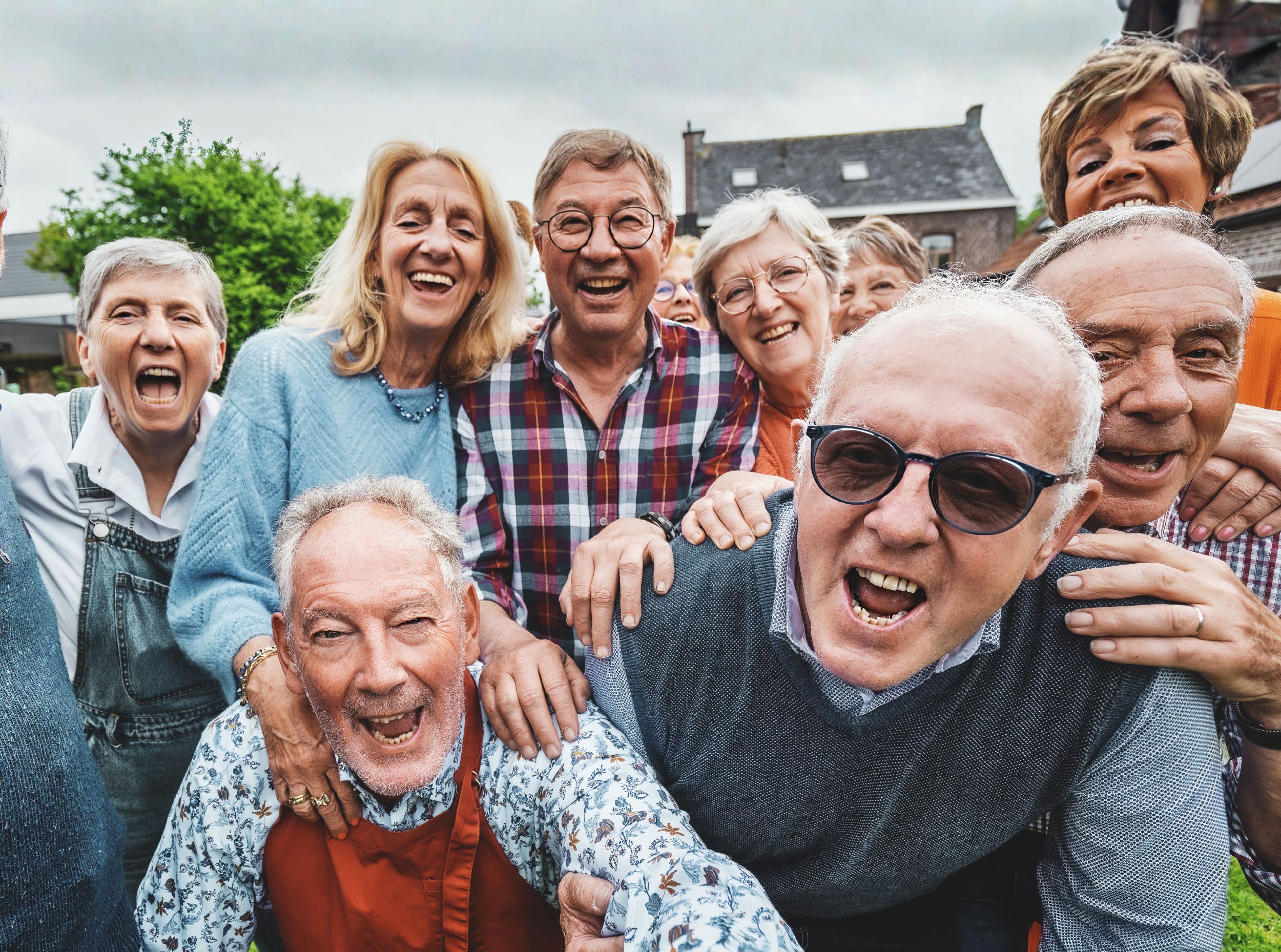 Group of cheerful elderly friends outdoors laughing together