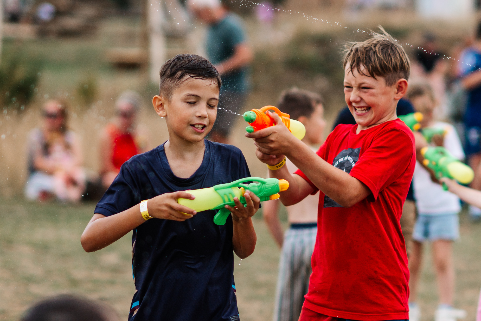 Children playing with water pistols in a sunny park