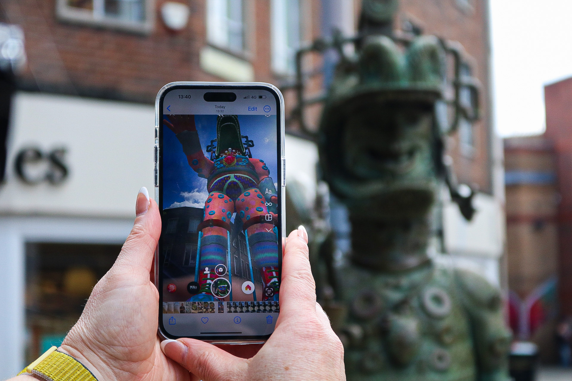 Colourful sculpture viewed through a smartphone in a busy street