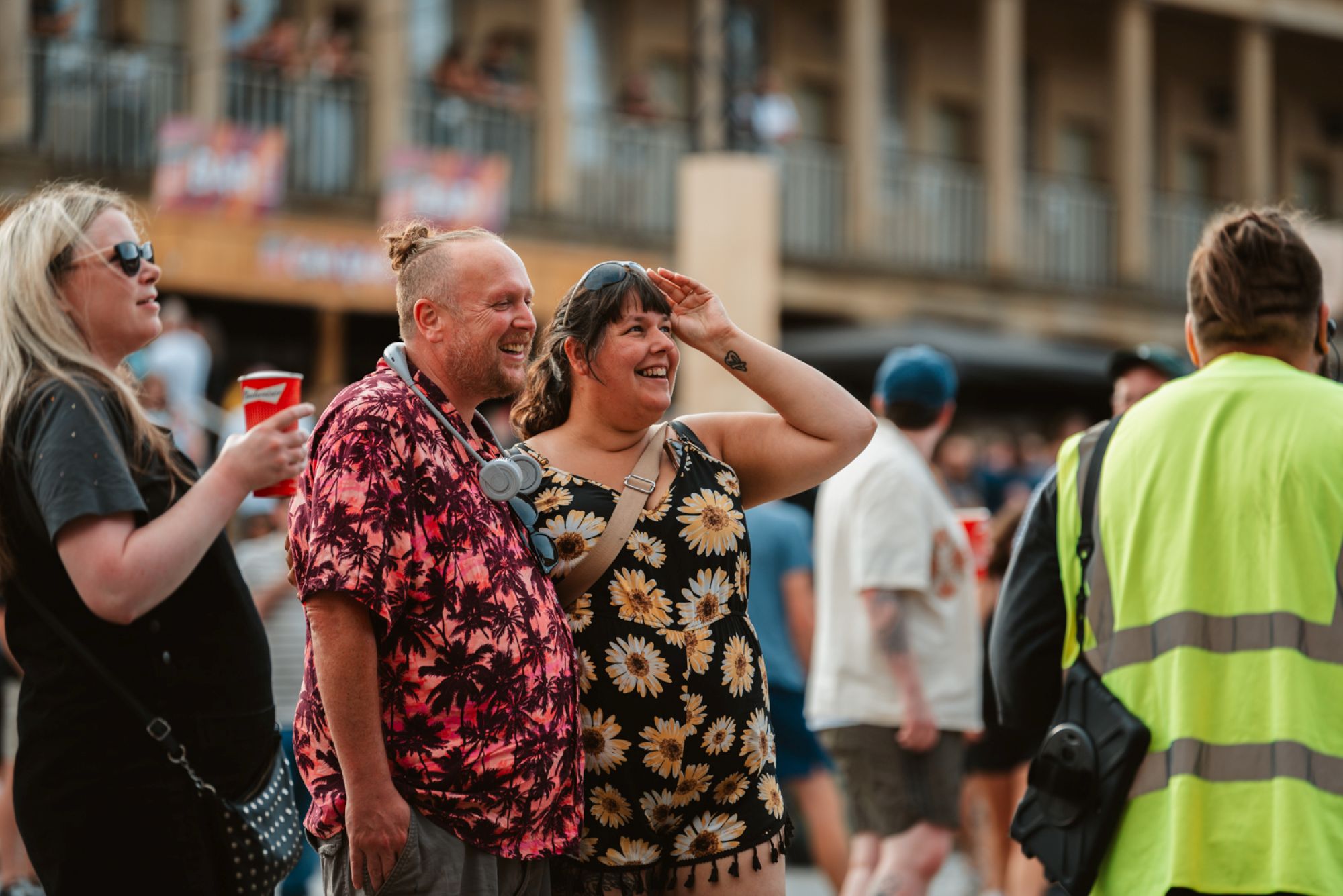 Smiling couple in summer attire at lively outdoor festival