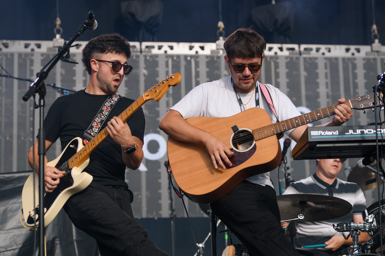 Musicians performing with guitars on outdoor stage