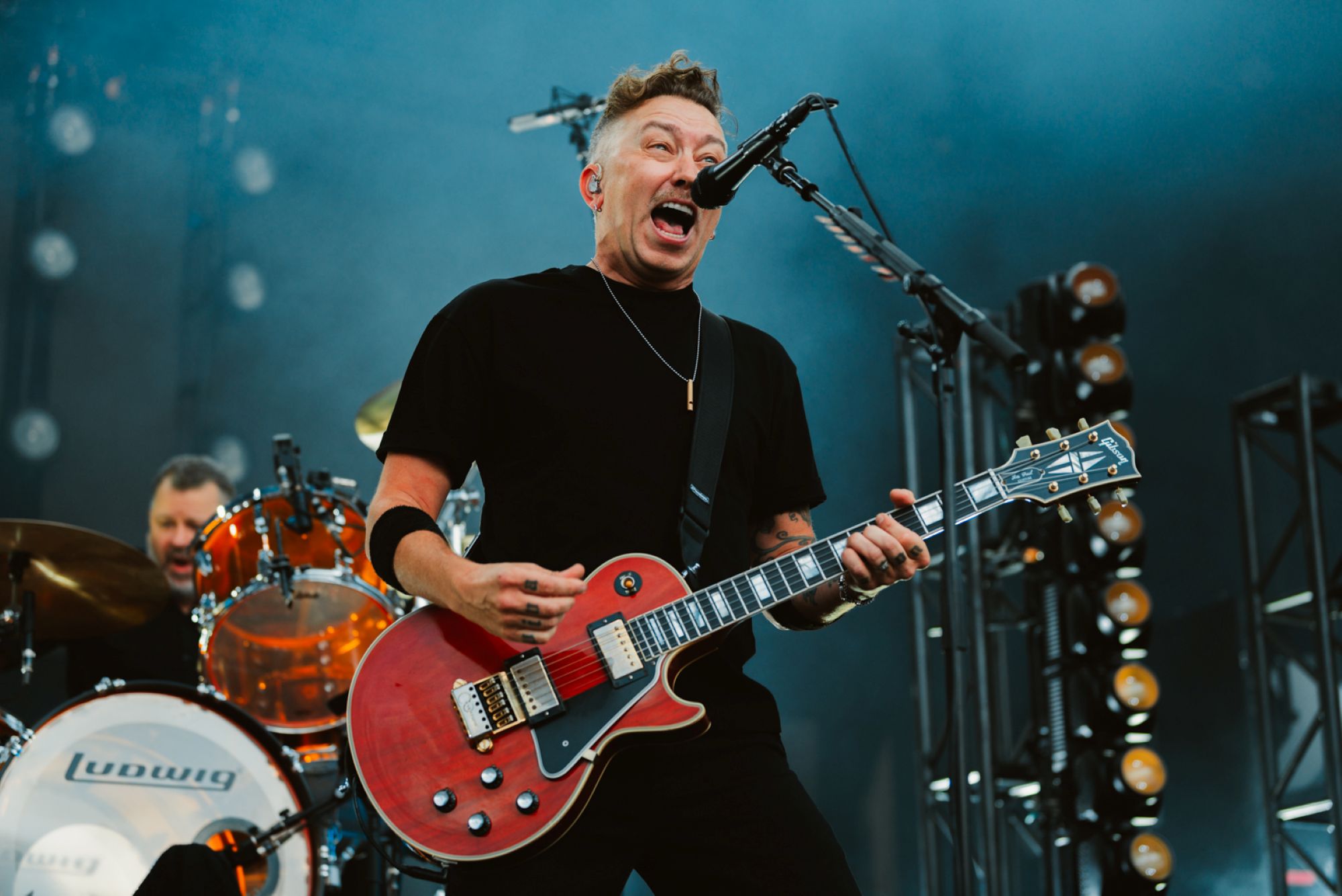 Musician passionately playing red electric guitar on stage