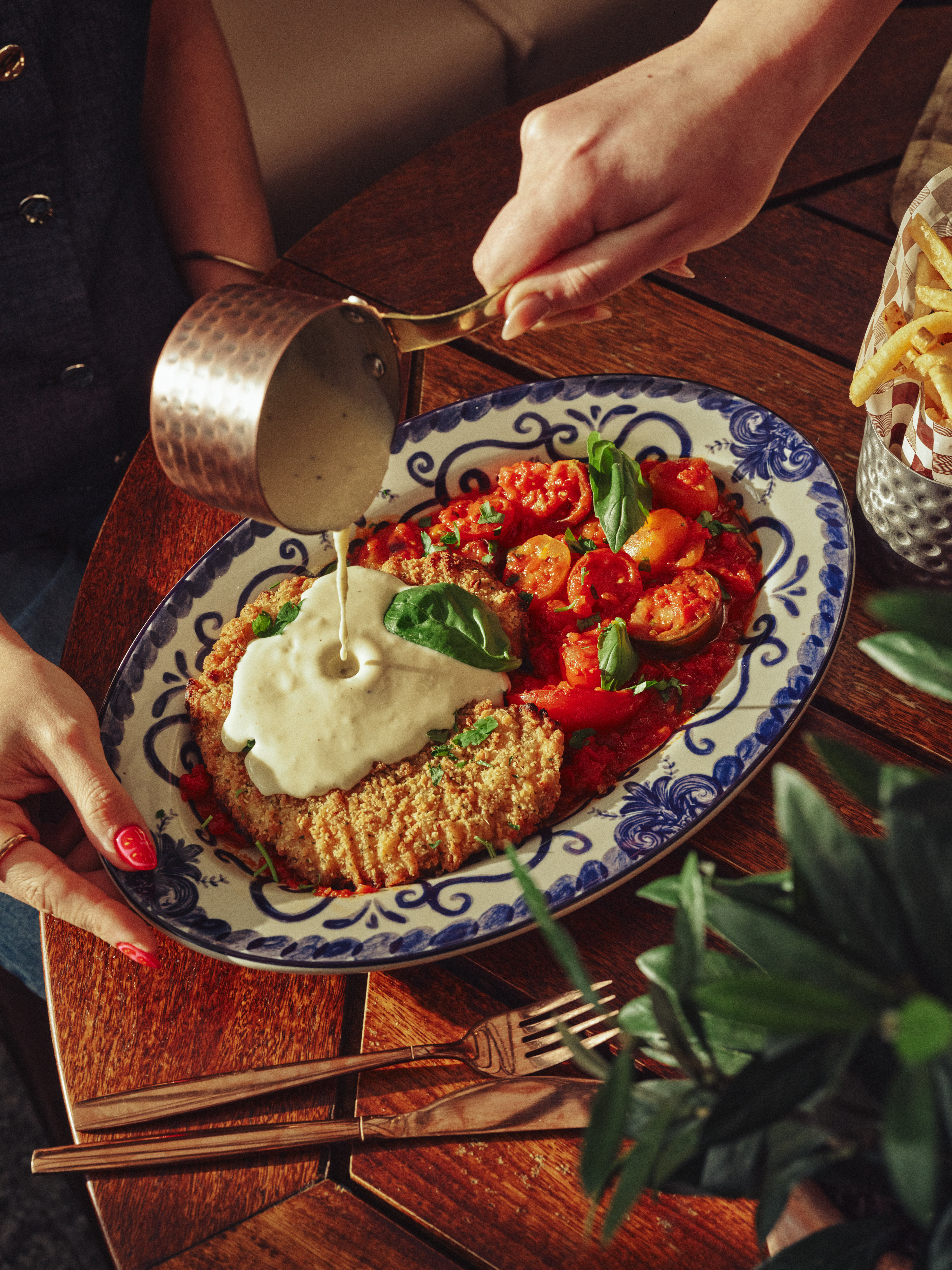 Cream sauce poured over breaded chicken with tomatoes