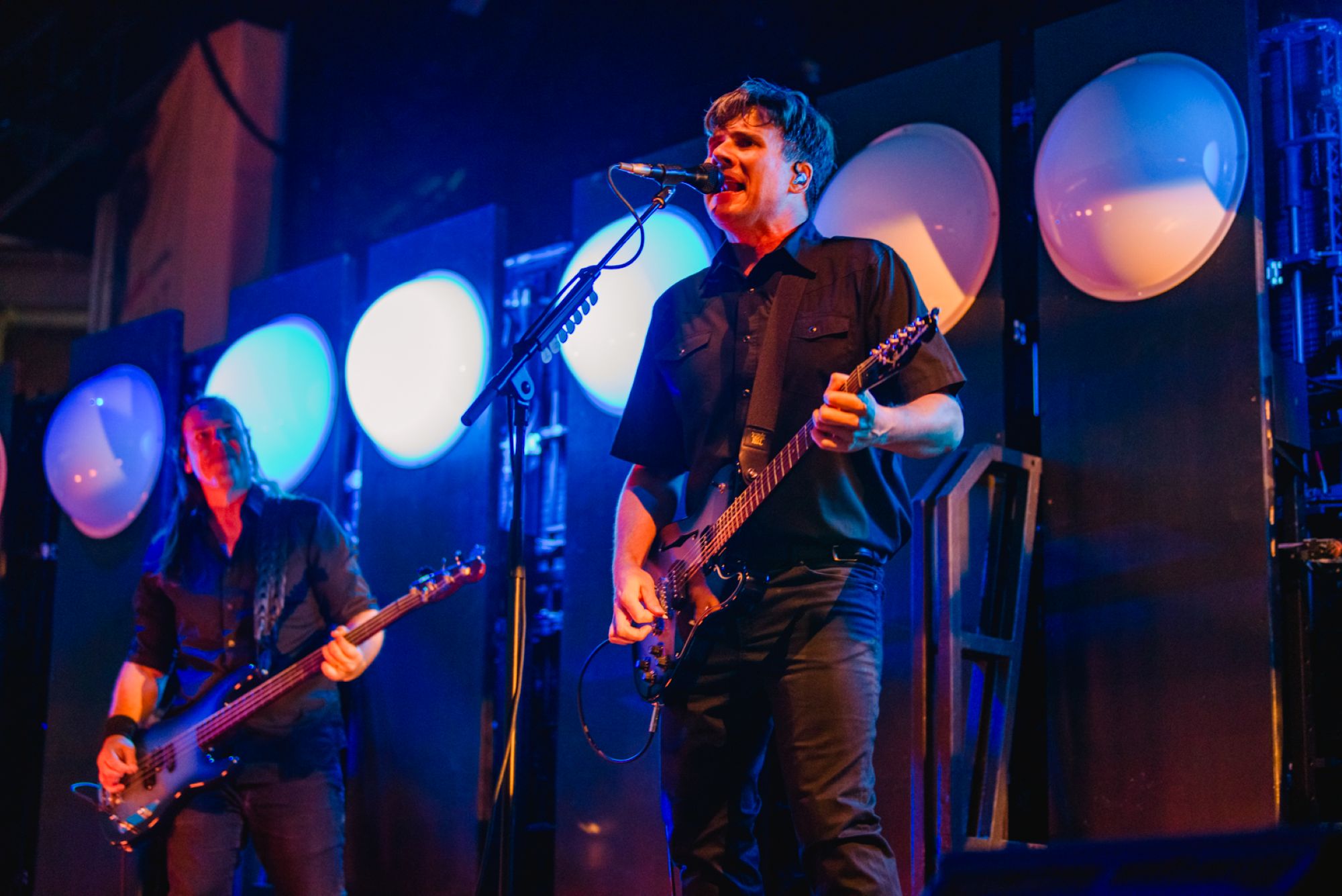 Band performing on stage with blue lights in background