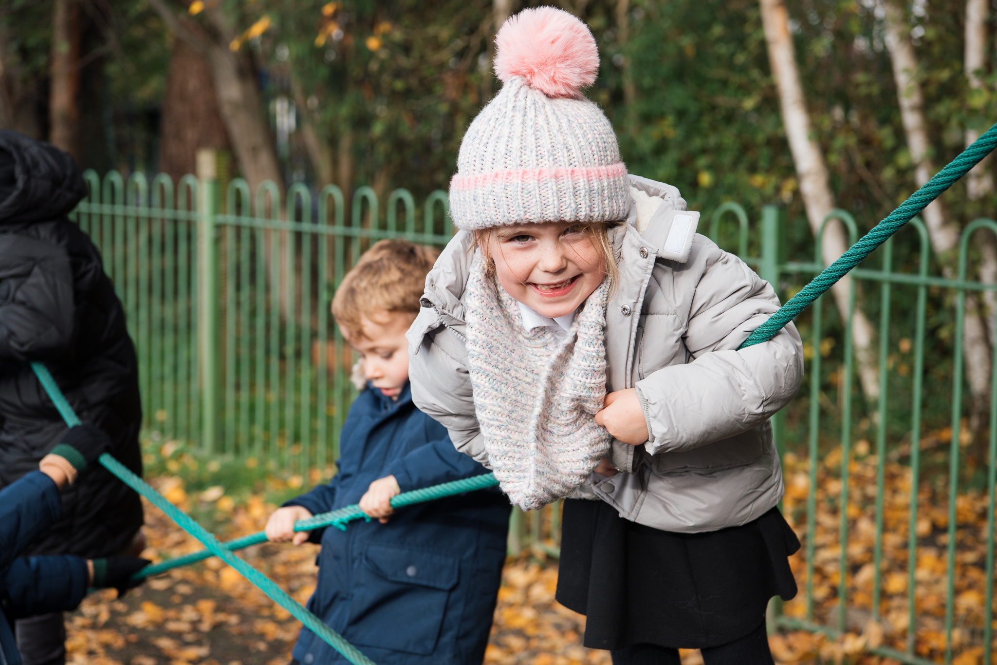 Children playing on ropes in an autumnal park setting