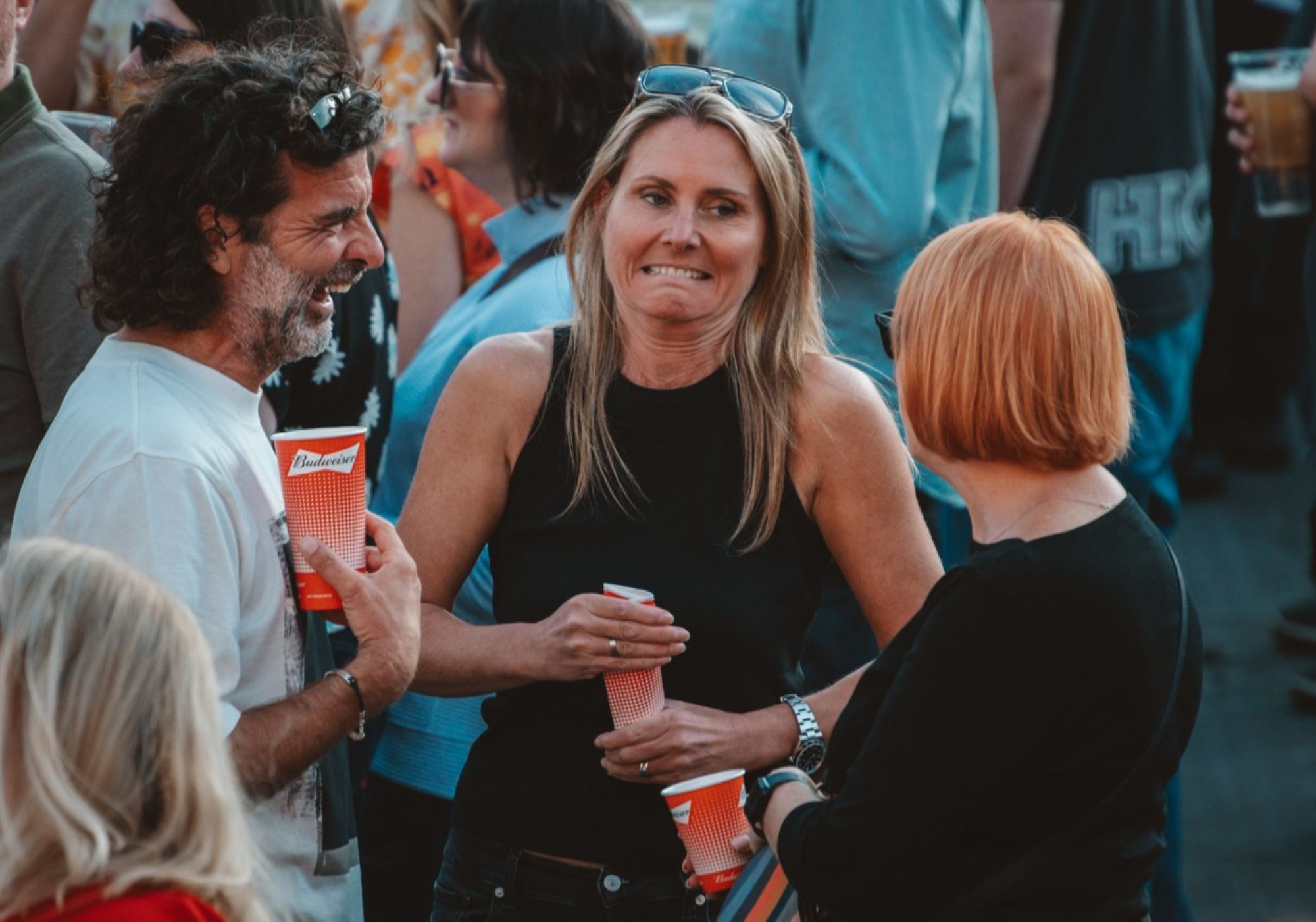 Group of people chatting at outdoor festival with drinks