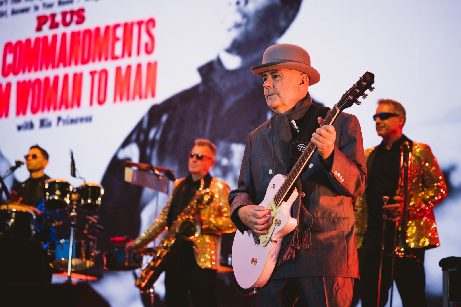 Band performing on stage with vibrant lighting and instruments