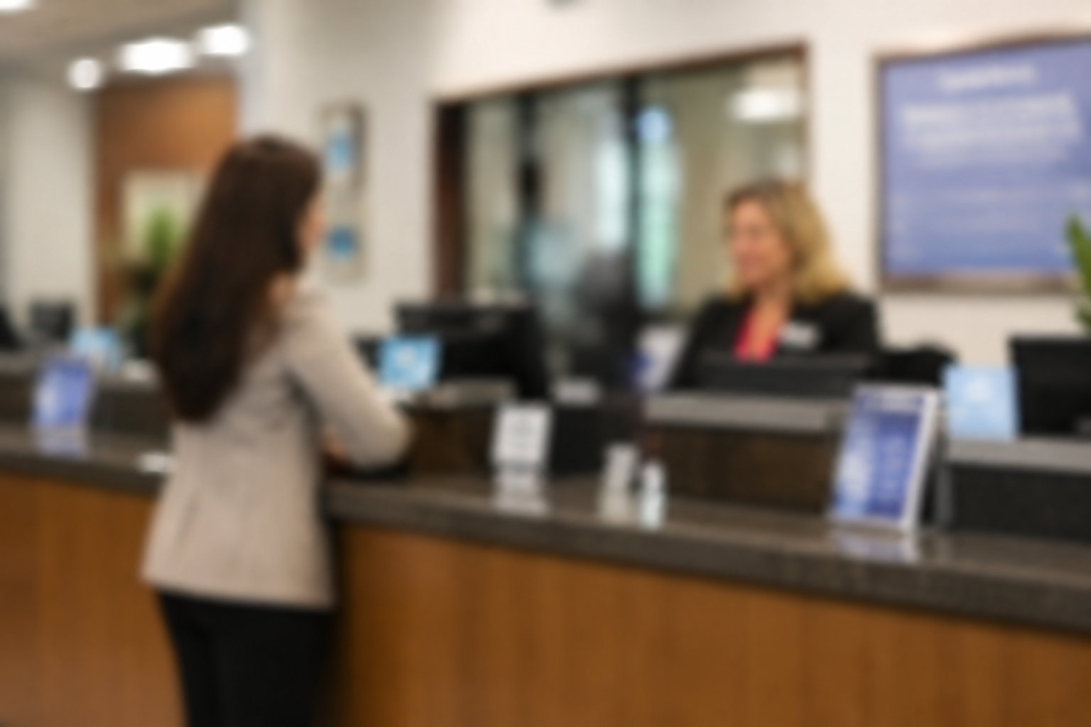 Woman at hotel reception desk talking to receptionist