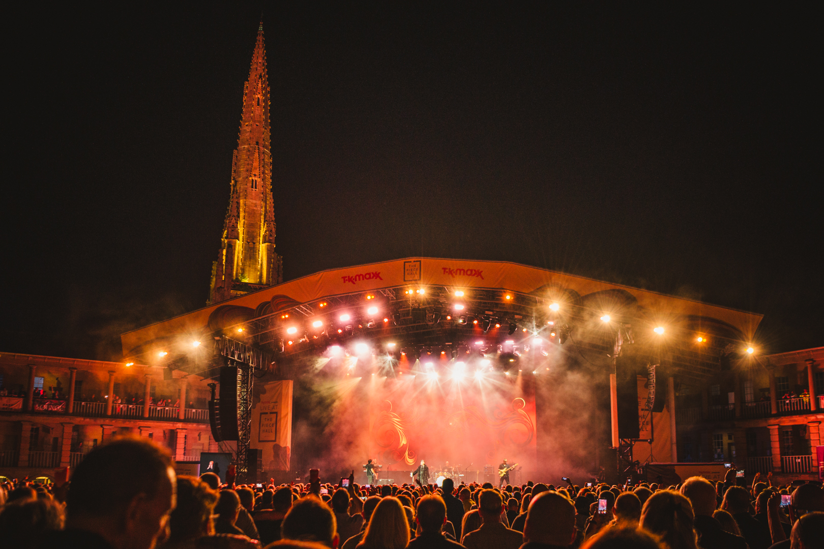 Outdoor evening concert with illuminated stage and crowd