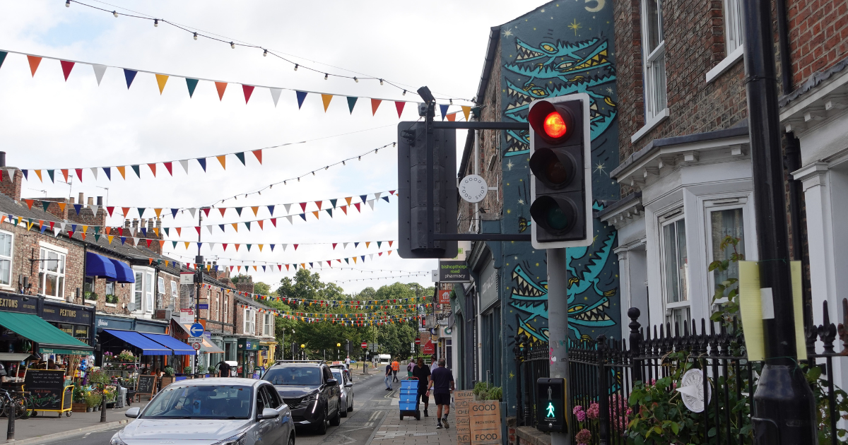 Bustling street in York with shops, bunting and traffic lights