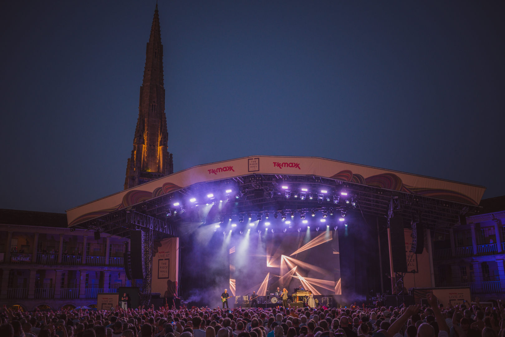 Outdoor evening concert with illuminated stage and crowd