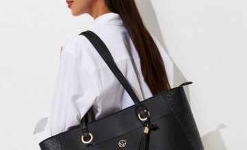 Woman in white shirt carrying a black leather handbag