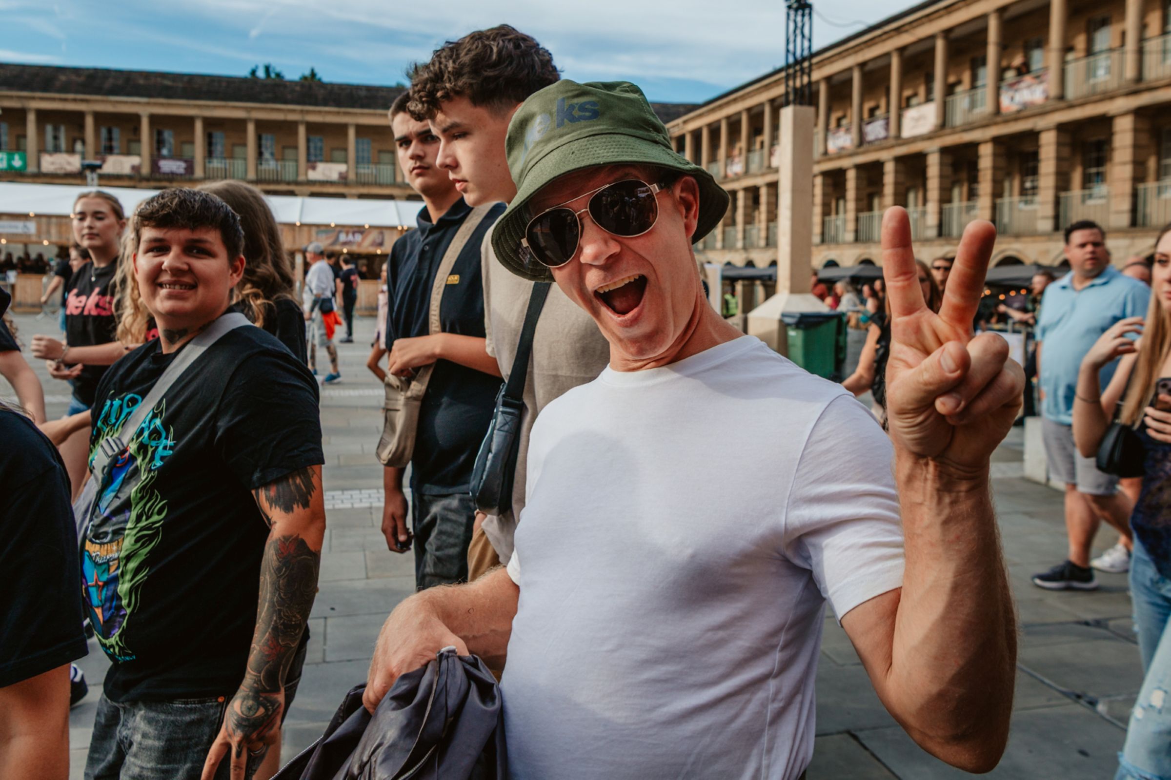 Group of smiling tourists at Halifax Piece Hall on a sunny day