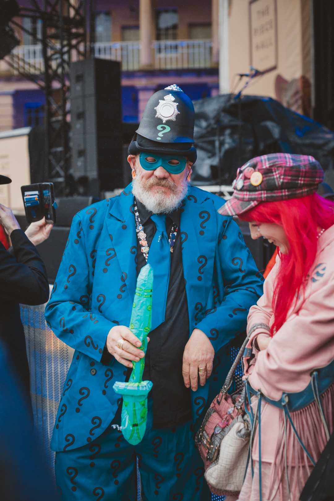 Man in question mark suit and police hat at outdoor event