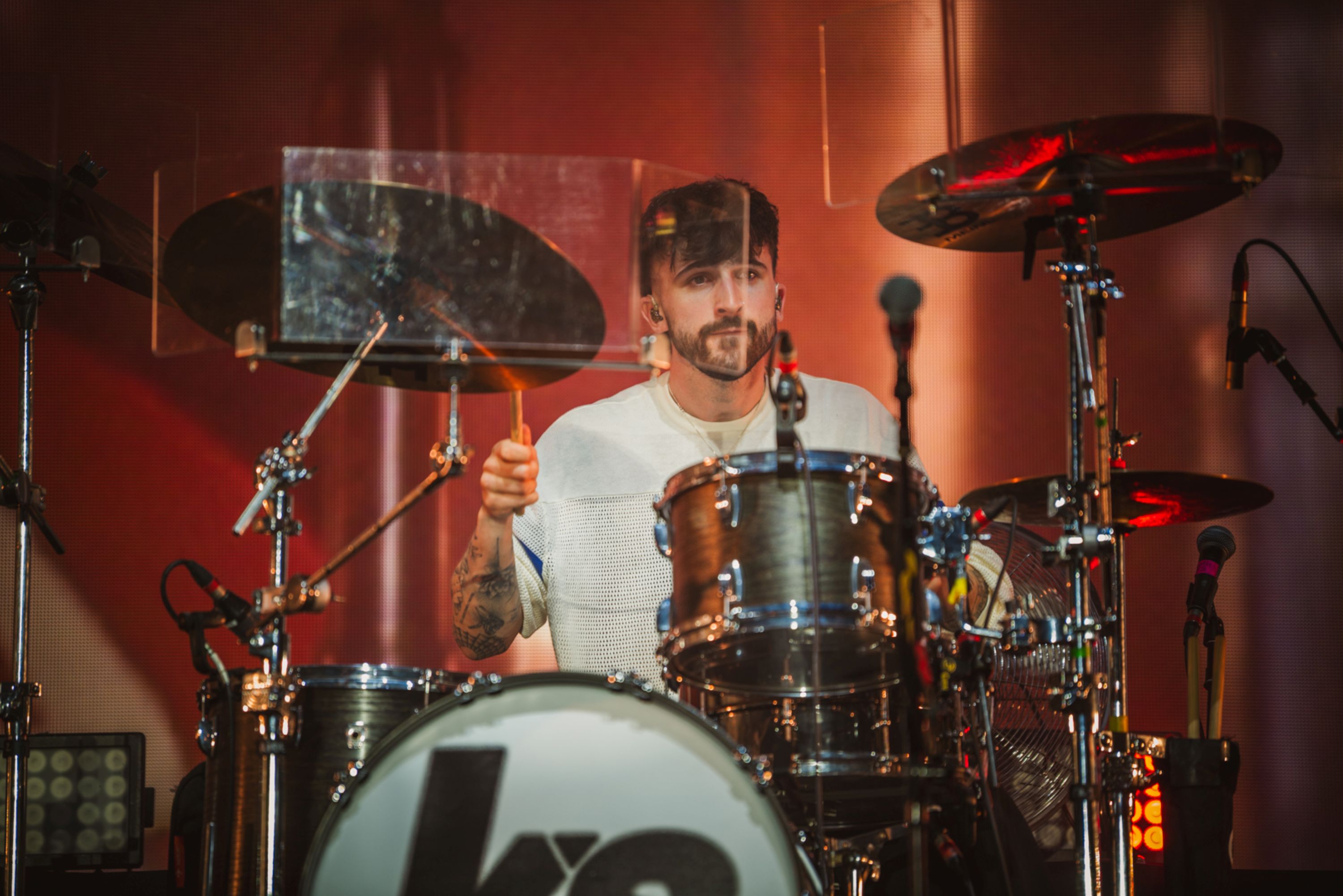 Drummer performing on stage with drum kit and cymbals