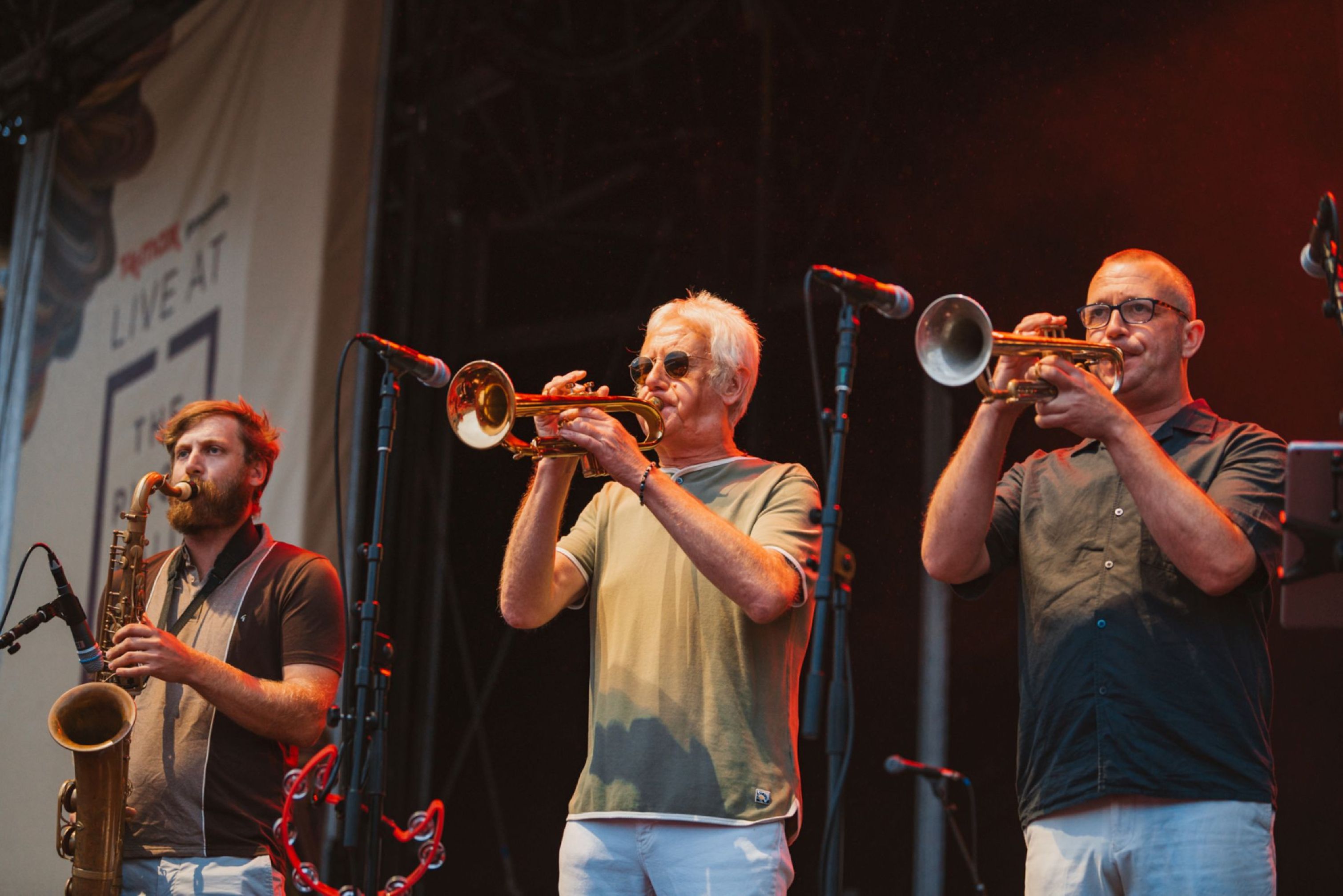 Jazz musicians performing on stage with trumpets and saxophone