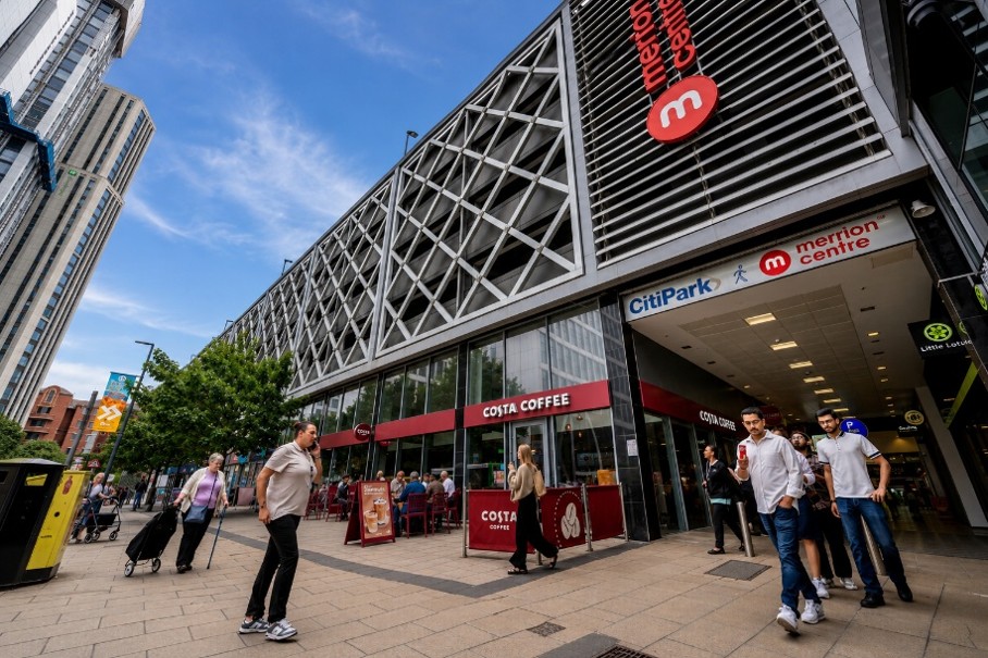 Modern shopping center with glass facade and pedestrians