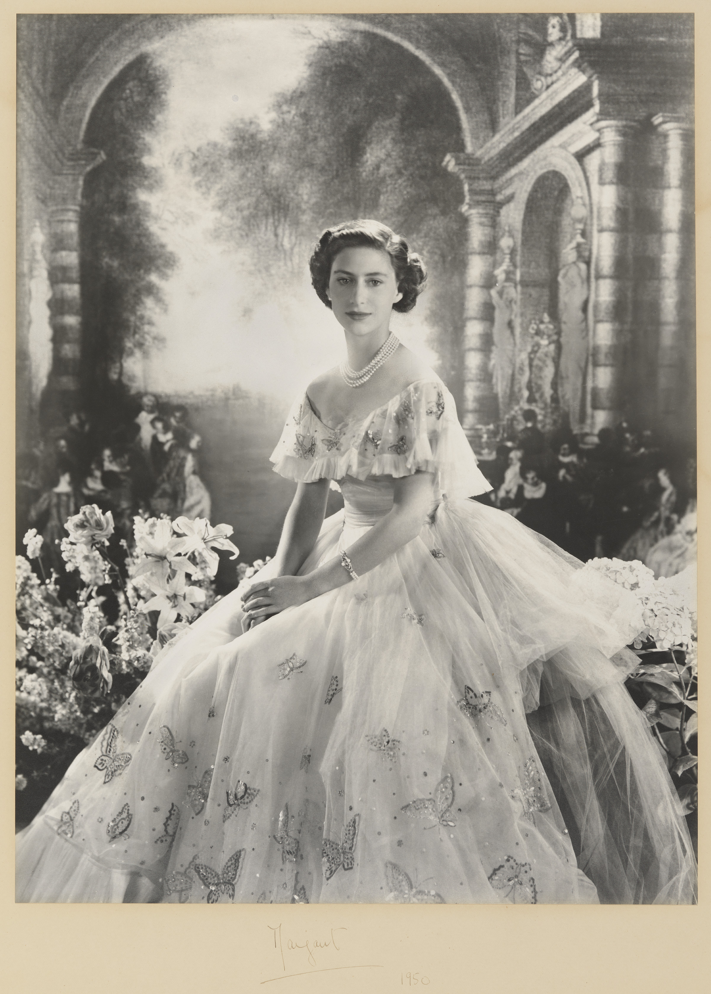 Elegant woman in a butterfly gown in front of a classical backdrop