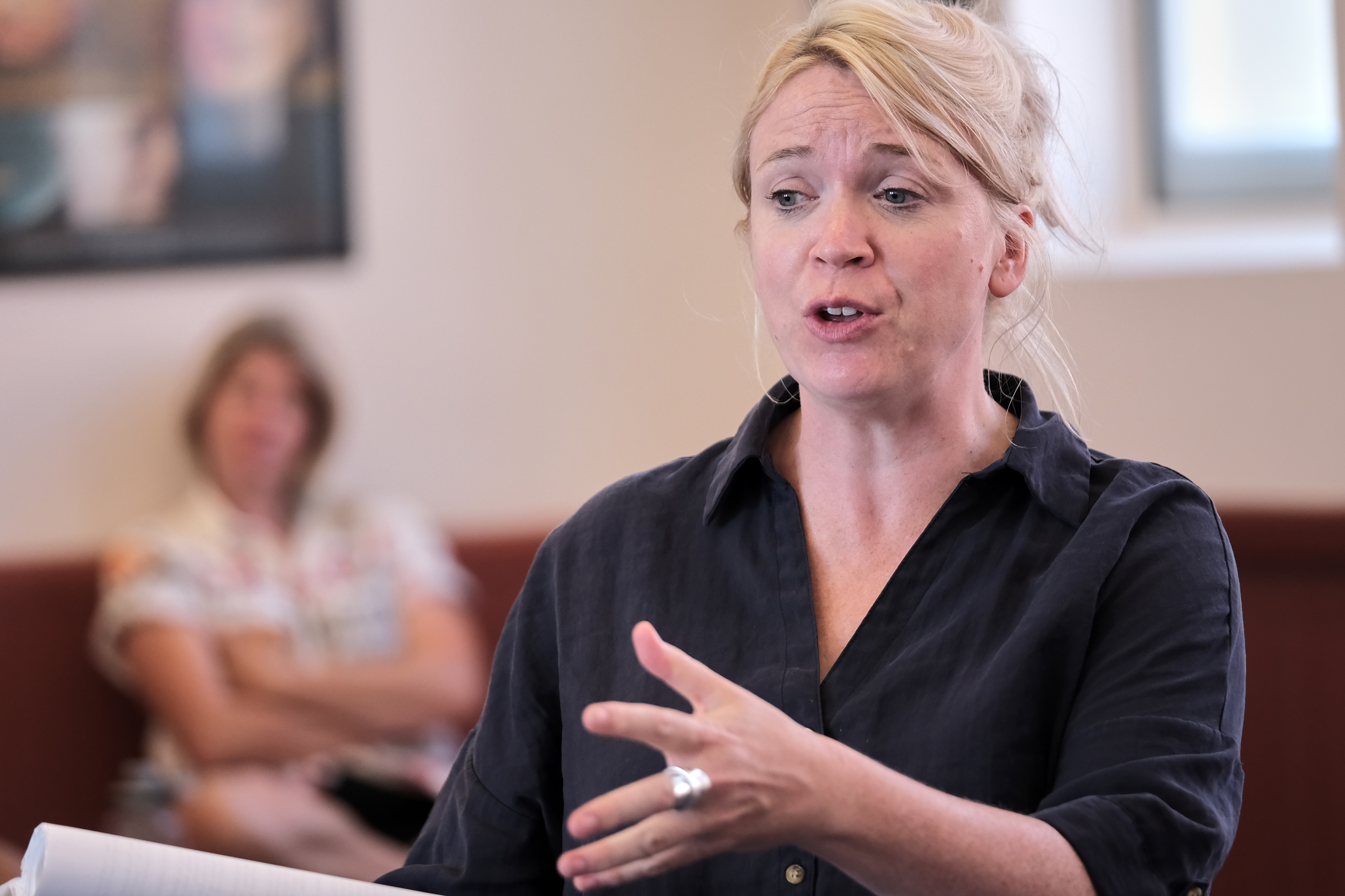 Blonde woman speaking passionately in a casual room setting