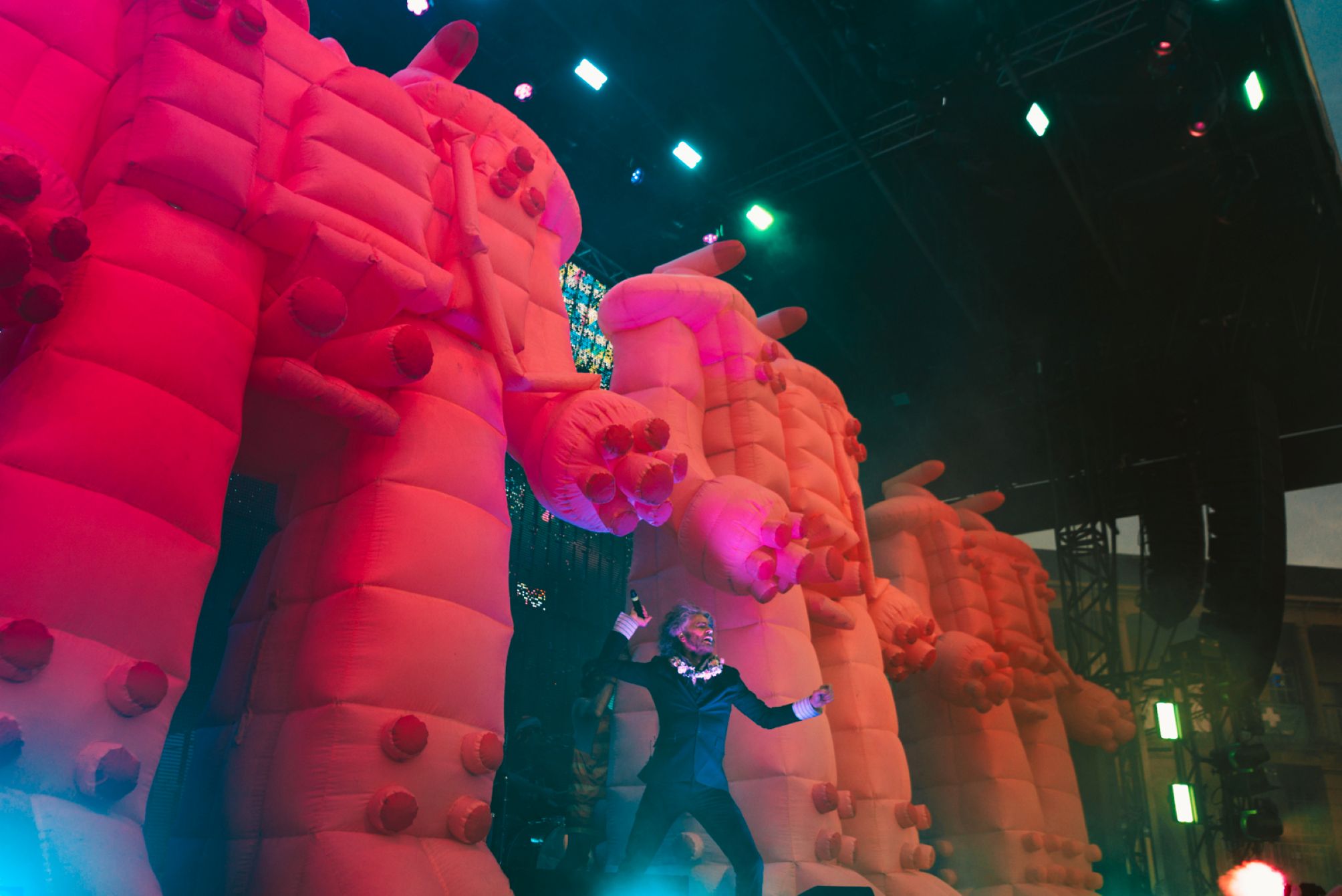 Performer on stage with large orange inflatable structures