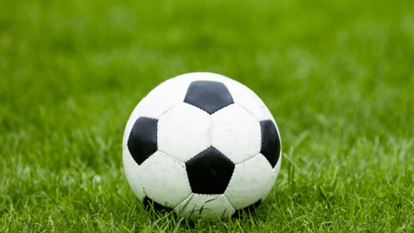Traditional black and white football on lush green grass