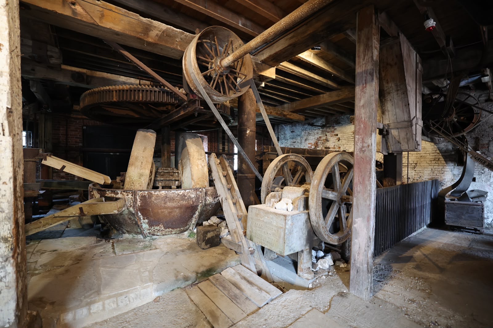 Historic water mill interior with wooden gears and stone walls