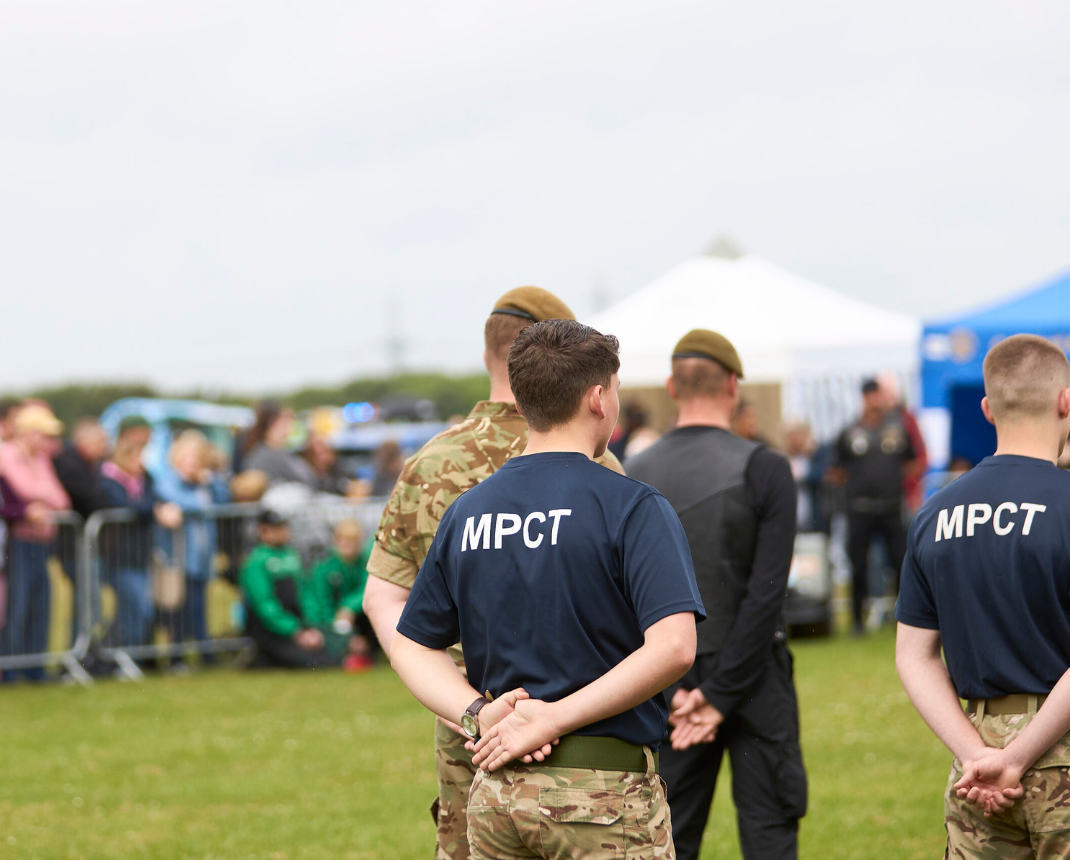 Young cadets in uniform at outdoor event with tents