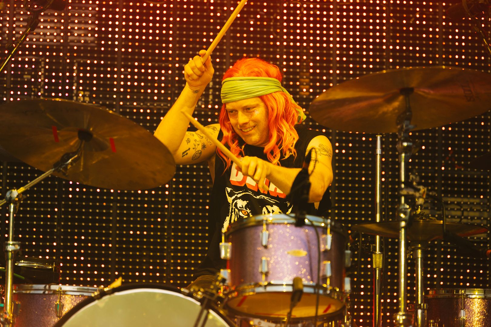 Drummer with red hair and bandana playing on stage